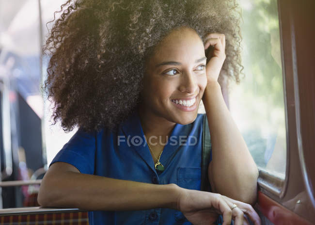 Sorrindo mulher com afro equitação ônibus olhando para fora da janela — Fotografia de Stock