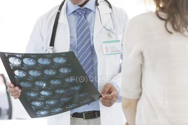 Доктор оглядає рентгенівські промені з пацієнтом — стокове фото