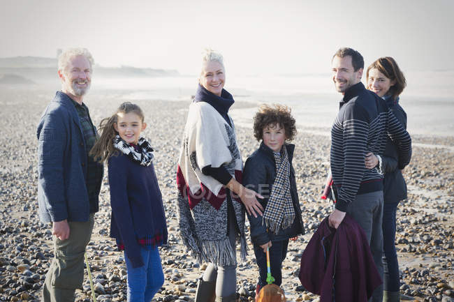 Retrato sonriente familia multi-generación en la playa soleada - foto de stock