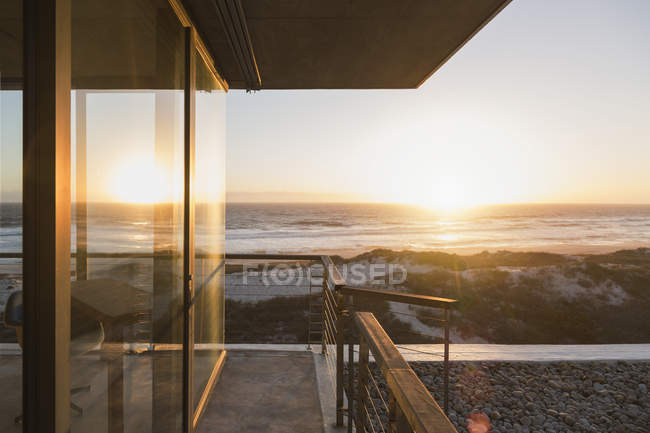 Вид на захід сонця над океаном із балконом сучасний будинок — стокове фото