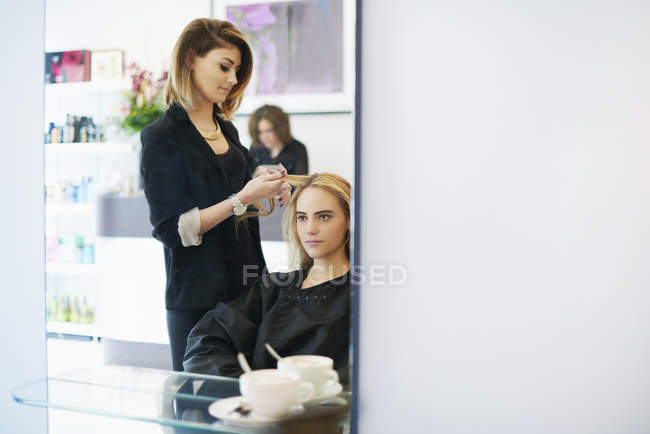 Парикмахер кёрлинг клиентов волосы в салоне — стоковое фото