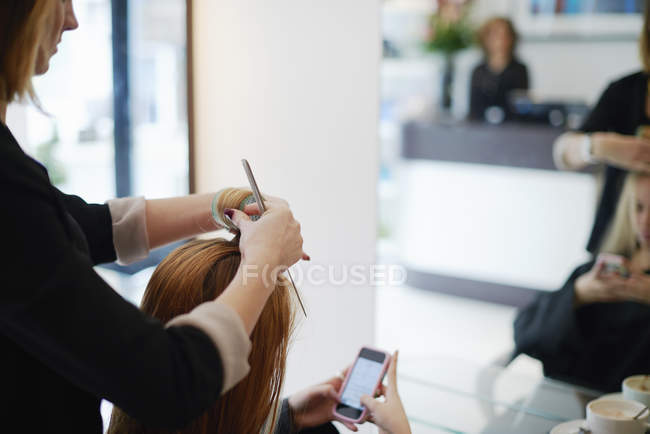 Coiffeur roulant les cheveux des clients dans les rouleaux dans le salon — Photo de stock