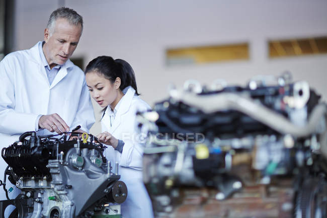 Successful adult scientists working on machine — Stock Photo