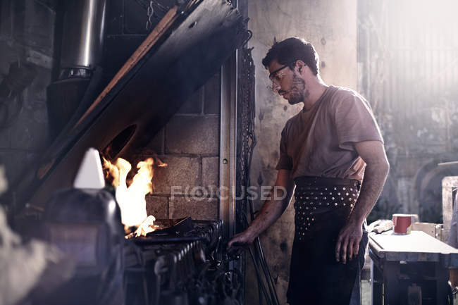 Кузнец, работающий на огне в кузнице — стоковое фото
