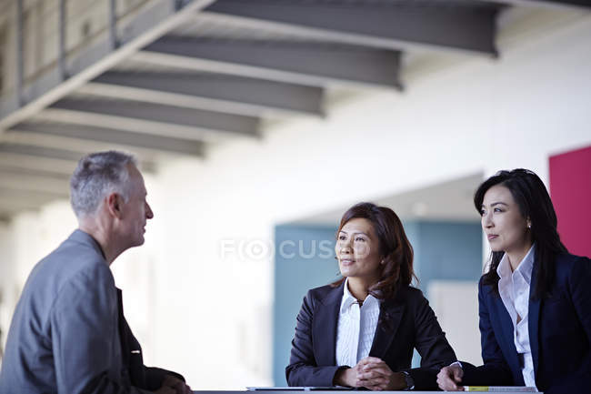 Gente de negocios adultos de éxito hablando en reunión - foto de stock