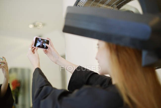 Cliente tomando selfie com telefone câmera no salão de cabeleireiro — Fotografia de Stock