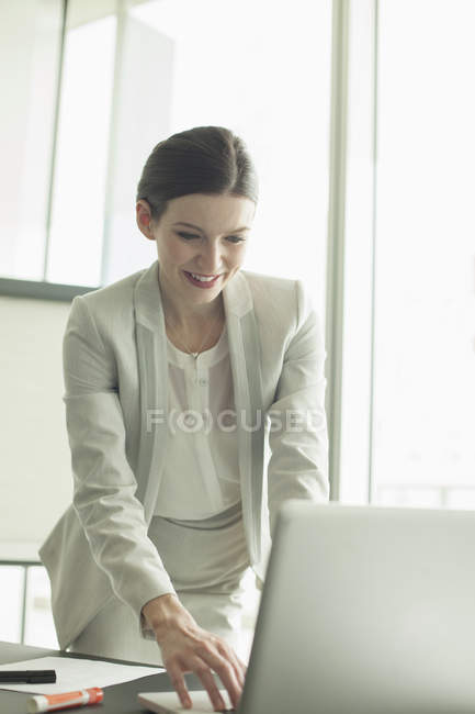 Бізнес-леді працює на ноутбуці в офісі — стокове фото
