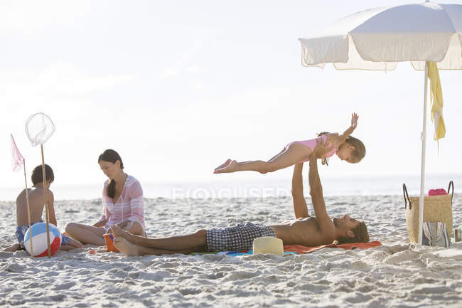 Família relaxando juntos na praia — Fotografia de Stock