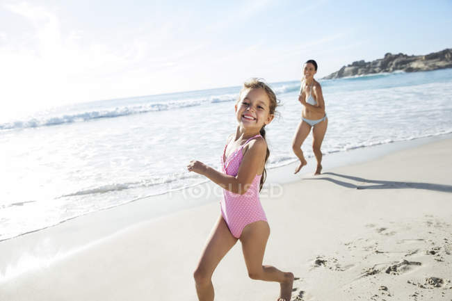 Mãe e filha correndo na praia — Fotografia de Stock