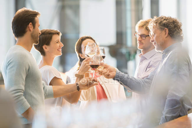 Freunde stoßen mit Weingläsern an — Stockfoto