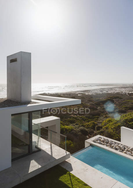 Modern house and lap pool overlooking ocean — Stock Photo