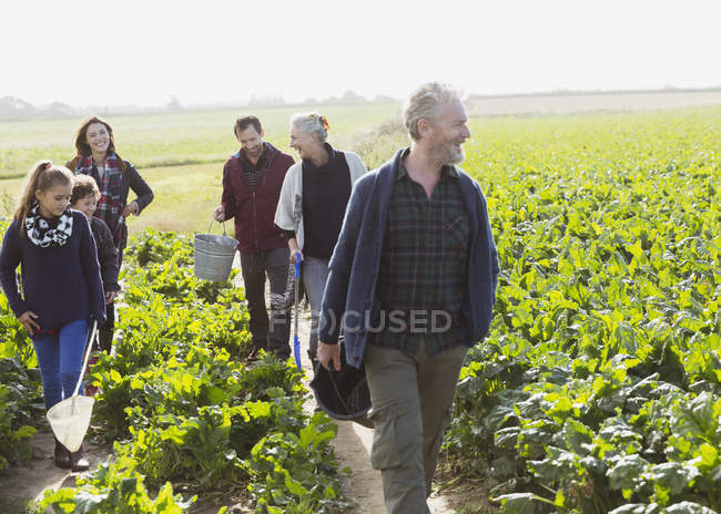 Multi-generation family walking in sunny vegetable garden — Stock Photo