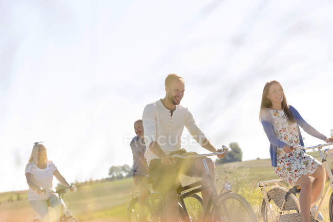 Balade à vélo en famille dans un champ rural ensoleillé — Photo de stock