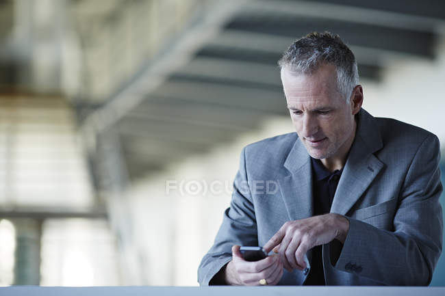 Exitoso hombre de negocios adulto utilizando el teléfono celular - foto de stock