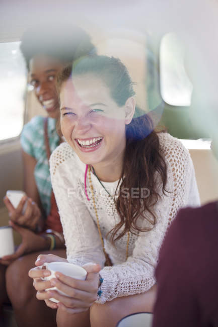 Women drinking coffee in back seat of van — Stock Photo