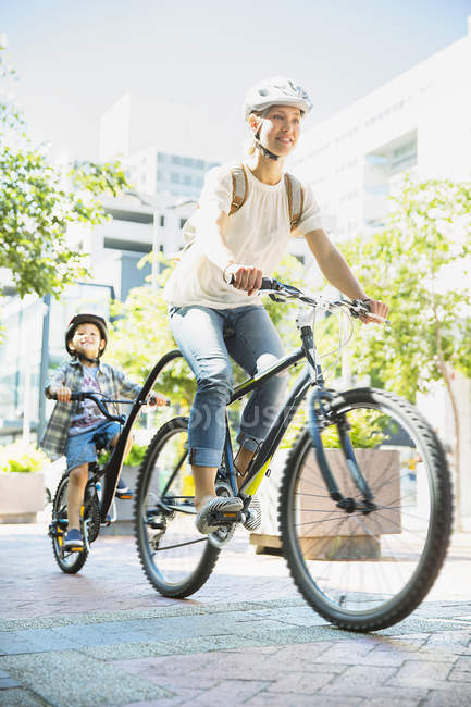 Mother and son riding bicycles on urban path — Stock Photo