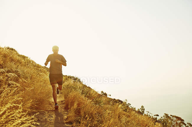 Uomo che corre sul sentiero del tramonto — Foto stock