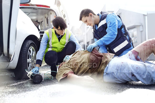Trabalhadores de salvamento vítimas de acidente de viação na estrada — Fotografia de Stock