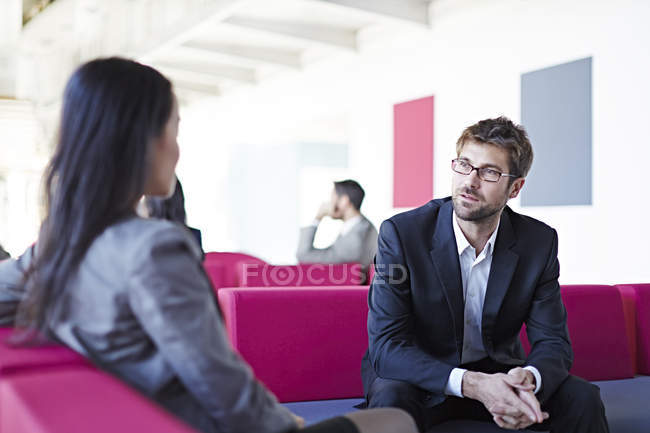 Успешные взрослые бизнесмены разговаривают в офисе — стоковое фото