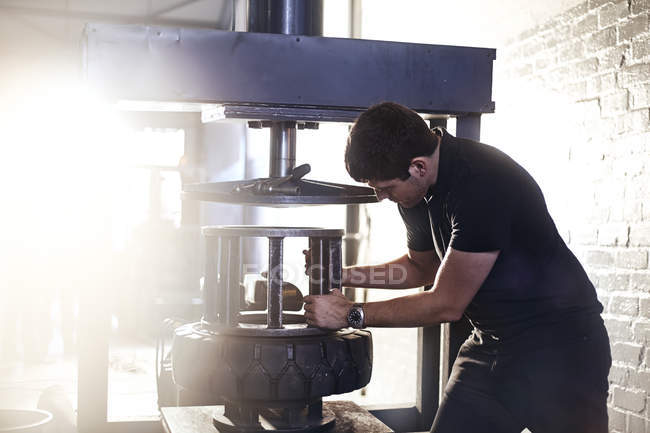 Mechaniker mit Reifenmontiermaschine in Autowerkstatt — Stockfoto