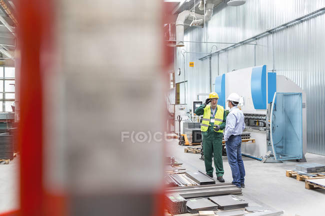 Engineer and worker talking in factory — Stock Photo