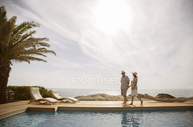 Coppia più anziana rilassarsi insieme a bordo piscina — Foto stock
