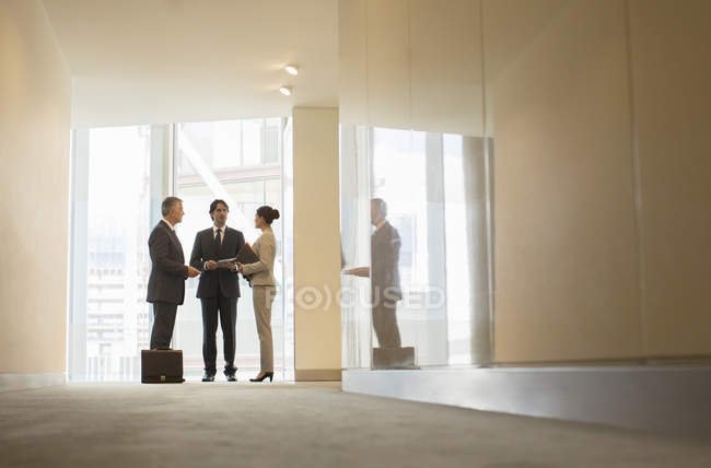 Geschäftsleute unterhalten sich am Bürofenster — Stockfoto