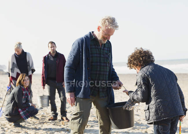 Multi-geração família clamming na praia ensolarada — Fotografia de Stock