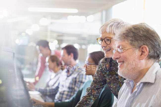 Students at computer in adult education classroom — Stock Photo