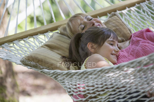 Woman and granddaughter relaxing in hammock — Stock Photo