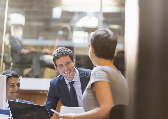 Sonrientes empresarios que trabajan en la oficina - foto de stock