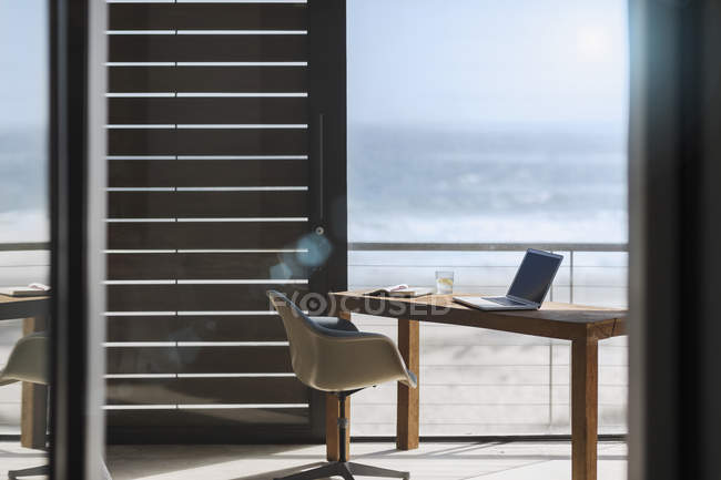 Стіл і стілець в сучасному домашньому офісі з видом на океан — стокове фото