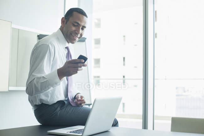 Бізнесмен використовує мобільний телефон в офісі — стокове фото