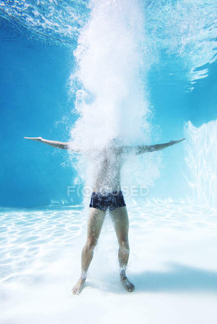 Человек, стоящий под водой в бассейне — стоковое фото