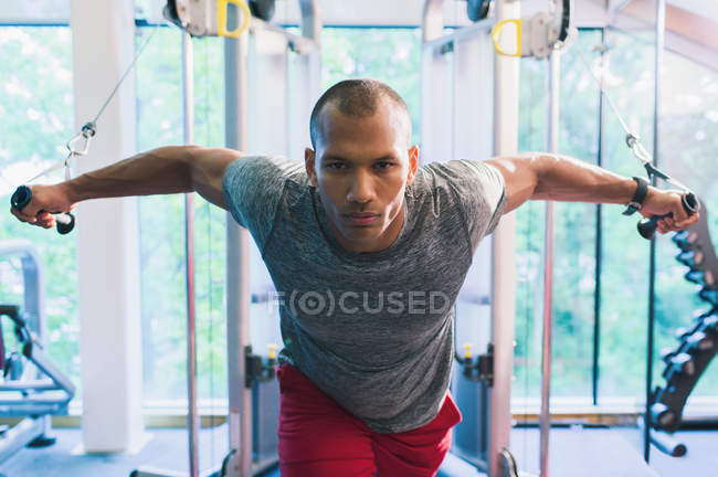 Determined man doing cable chest fly at gym — Stock Photo