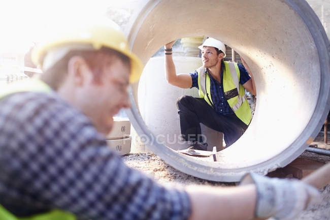 Trabajador de construcción examinando tubería de hormigón - foto de stock