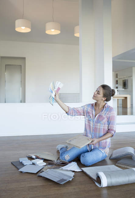 Frau sieht sich Farbtupfer in neuem Haus an — Stockfoto