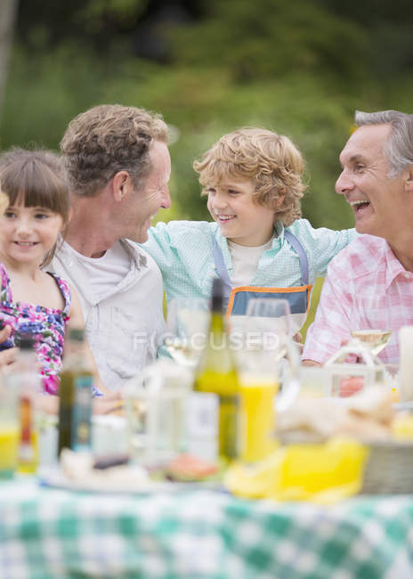 Família desfrutando de almoço à mesa ao ar livre — Fotografia de Stock