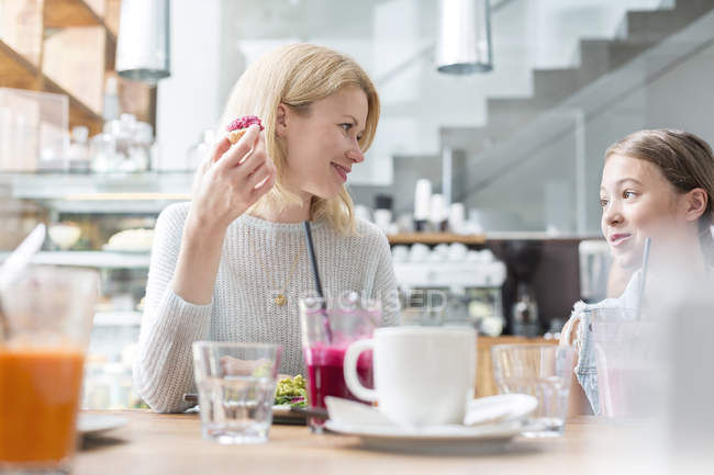 Mother and daughter eating at cafe table — Stock Photo