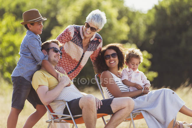 Семья из нескольких поколений отдыхает на солнечном поле — стоковое фото