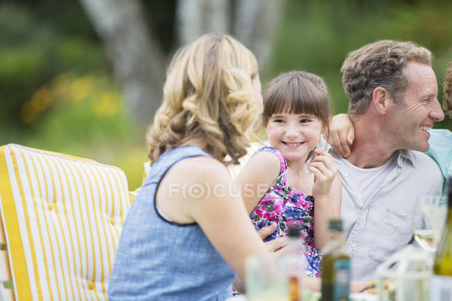 Happy family eating together outdoors — Stock Photo