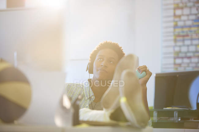 Businessman relaxing at desk in modern office — Stock Photo