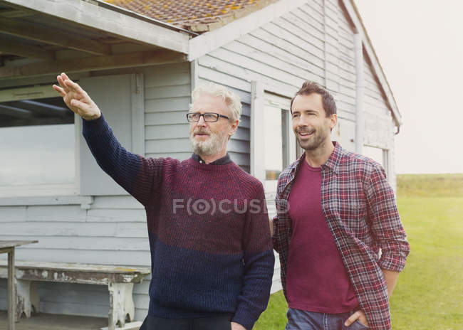 Father gesturing to son outside house — Stock Photo