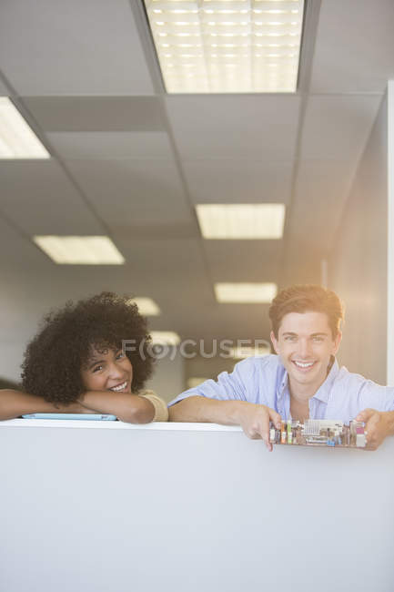 Retrato de gente de negocios sonriente sosteniendo placa de circuito en la oficina - foto de stock