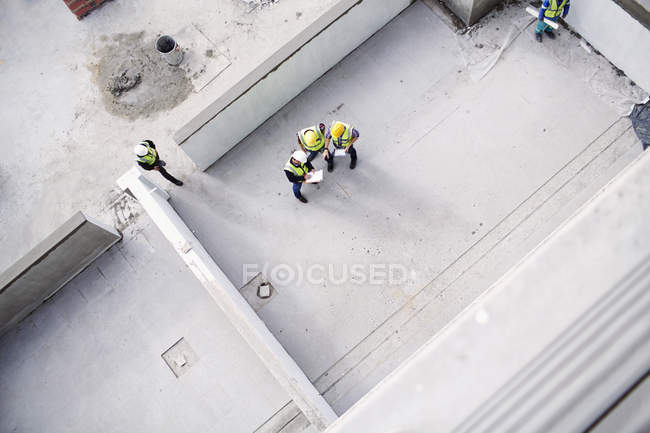 Vista aérea de los trabajadores de la construcción y los ingenieros en el sitio de construcción - foto de stock