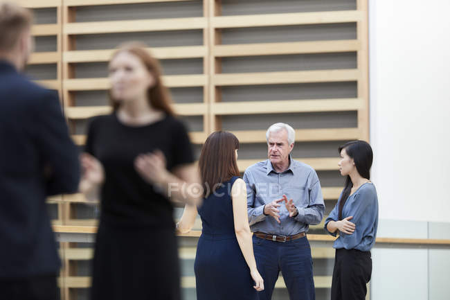 Деловые люди разговаривают в холле — стоковое фото