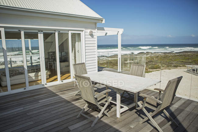 Tavolo e sedie sul balcone con vista sulla spiaggia — Foto stock