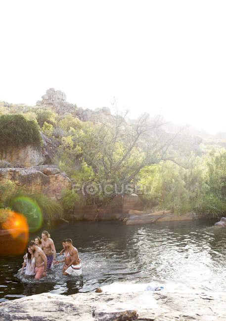 Друзі бродяться в річці вдень — стокове фото