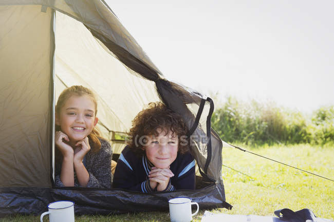 Портрет улыбающиеся брат и сестра в палатке — стоковое фото