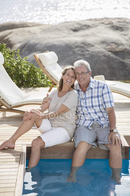 Пара пожилых людей, отдыхающих у бассейна — стоковое фото